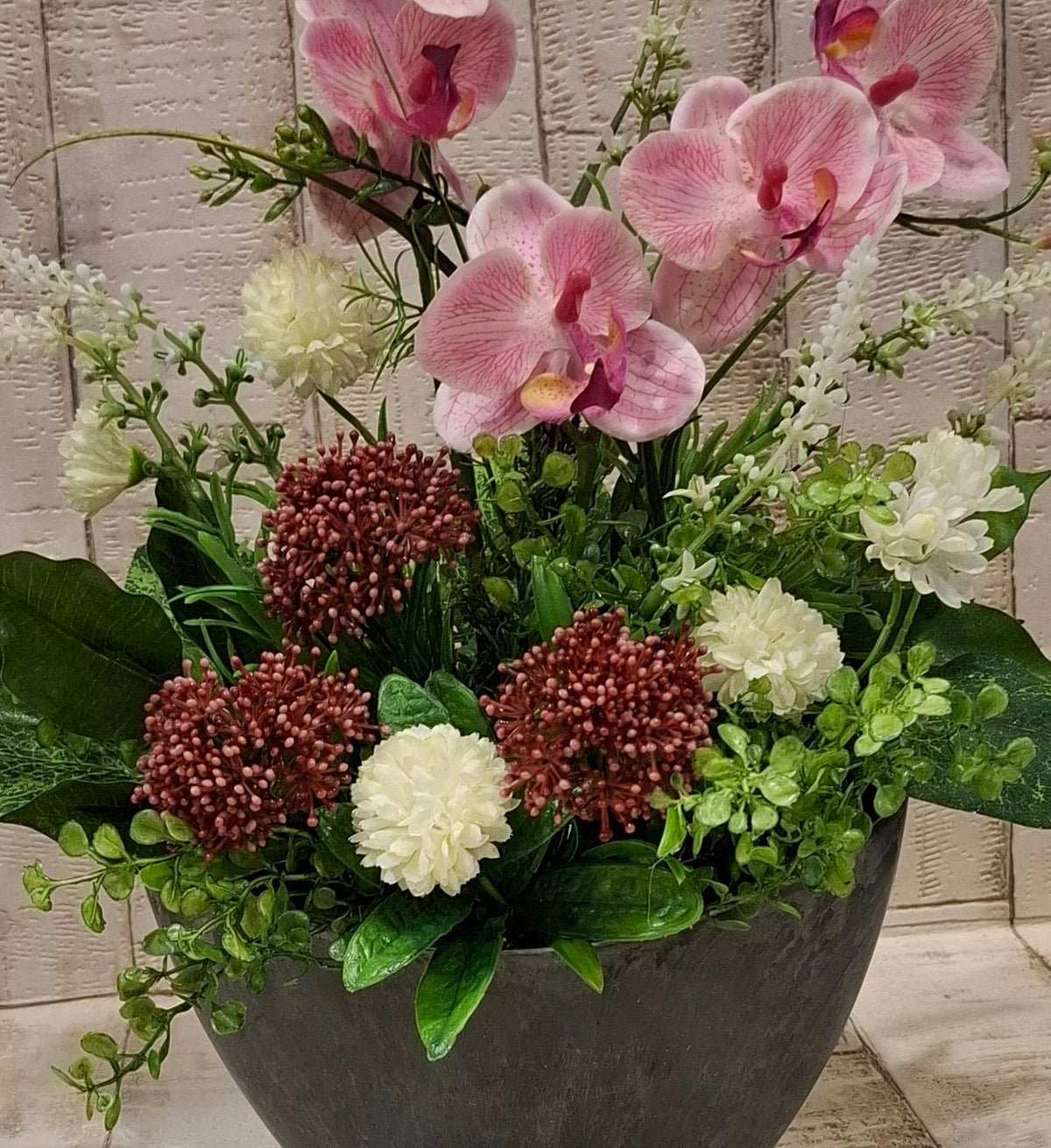 Detailansicht der Blüten, Blätter und des grauen Gefäßes