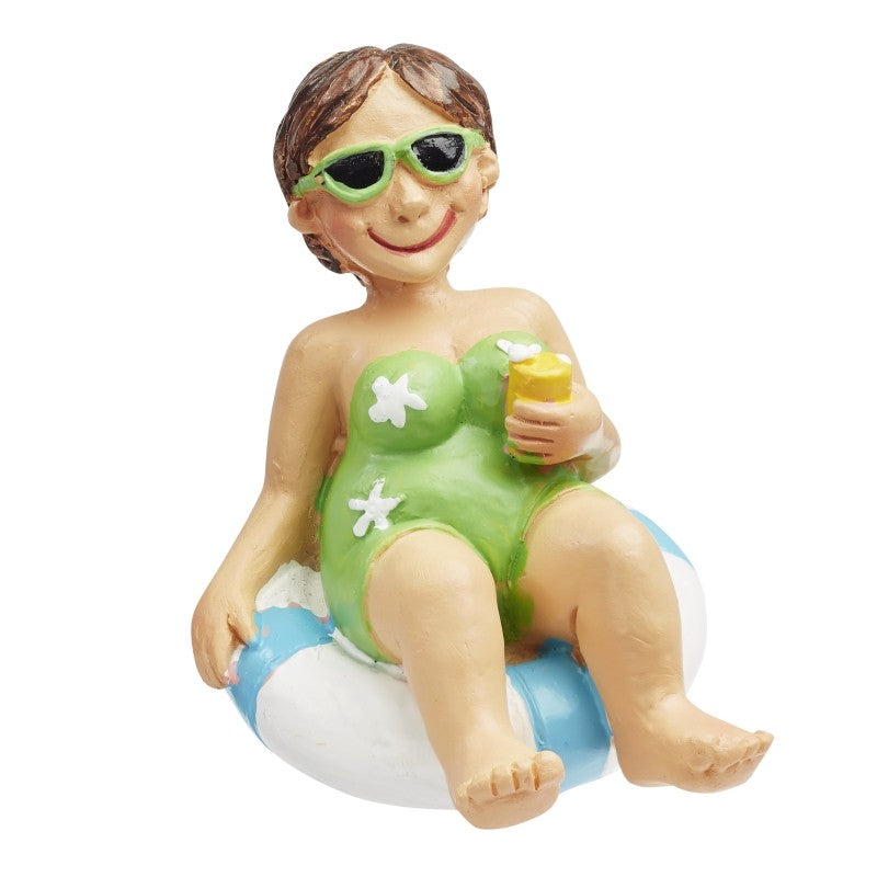Miniatur-Urlauberin im grünen Badeanzug mit Sonnenbrille und Getränk in einem blau-weißen Schwimmreifen