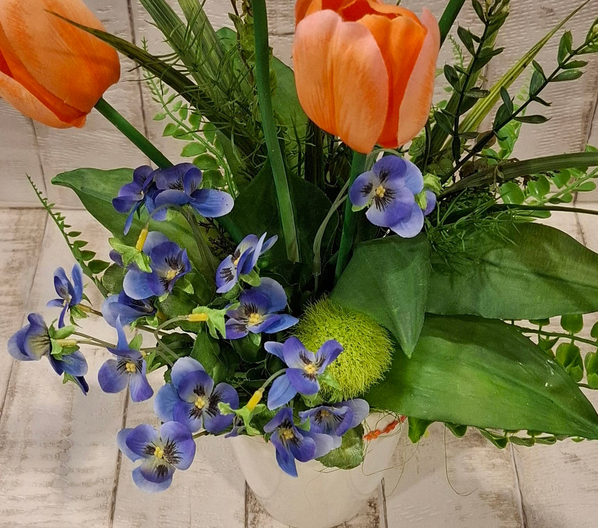 Nähere Ansicht der orangefarbenen Tulpen und blauen Stiefmütterchen