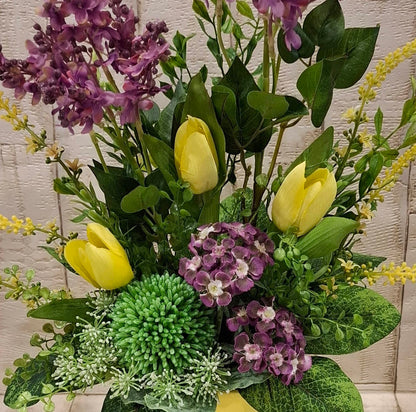 Detailansicht der gelben Tulpen, lila Primeln und des Grüns