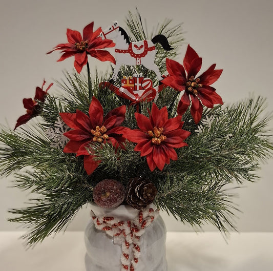 Detailansicht der roten Blüten, Zapfen und des Dekopferds im Weihnachtsgesteck