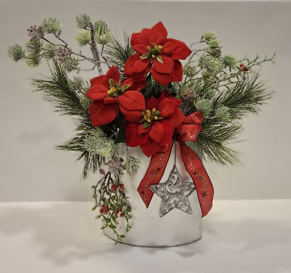 Weihnachtsgesteck in silberner Keramikvase mit roten Blüten, roter Schleife und Dekostern – Gesamtansicht