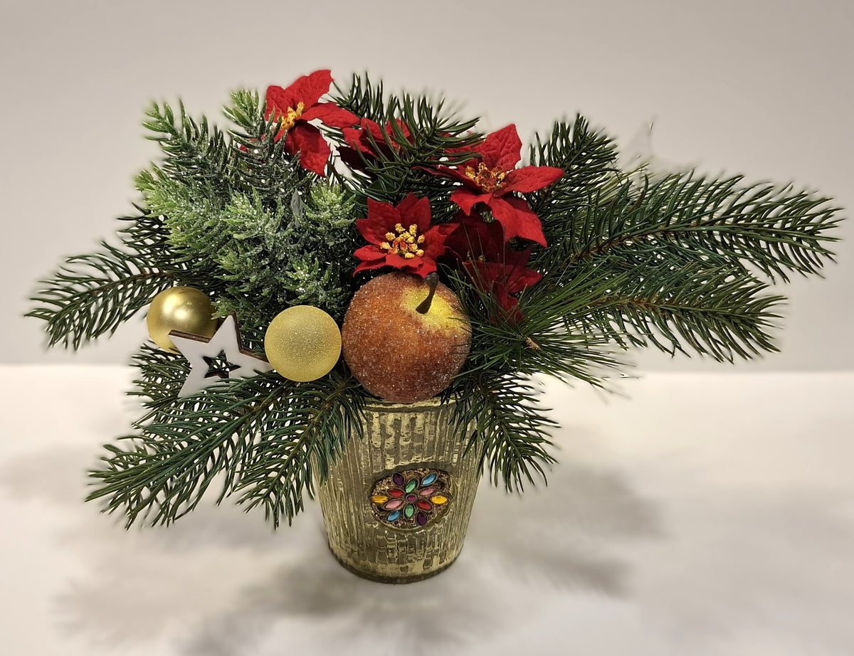 Weihnachtsgesteck im dekorativen Glas mit roten Blüten, goldfarbenen Kugeln und Dekoapfel – Gesamtansicht