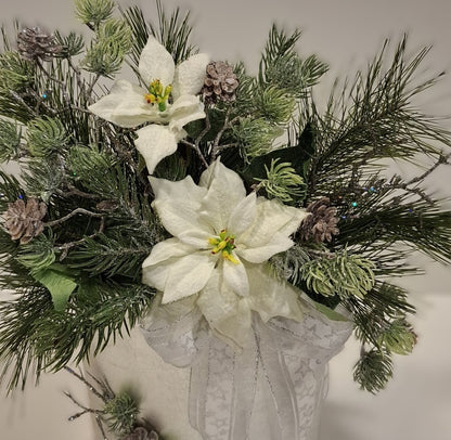 Detailansicht der weißen Blüten, Zapfen und hellen Schleife im Weihnachtsgesteck