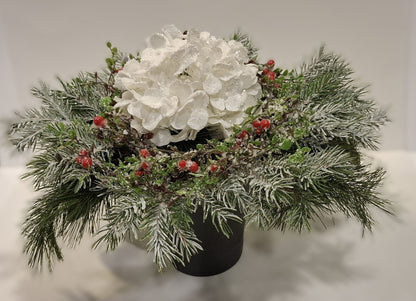 Großes Weihnachtsgesteck mit weißer Glitter-Hortensie, roten Beeren und winterlichen Zweigen im dunklen Keramikgefäß