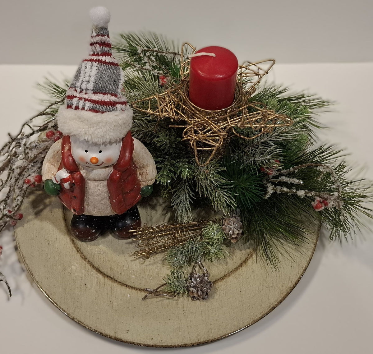 Detailansicht von Schneemann, grünen Zweigen und roter Kerze