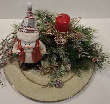 Detailansicht von Schneemann, grünen Zweigen und roter Kerze