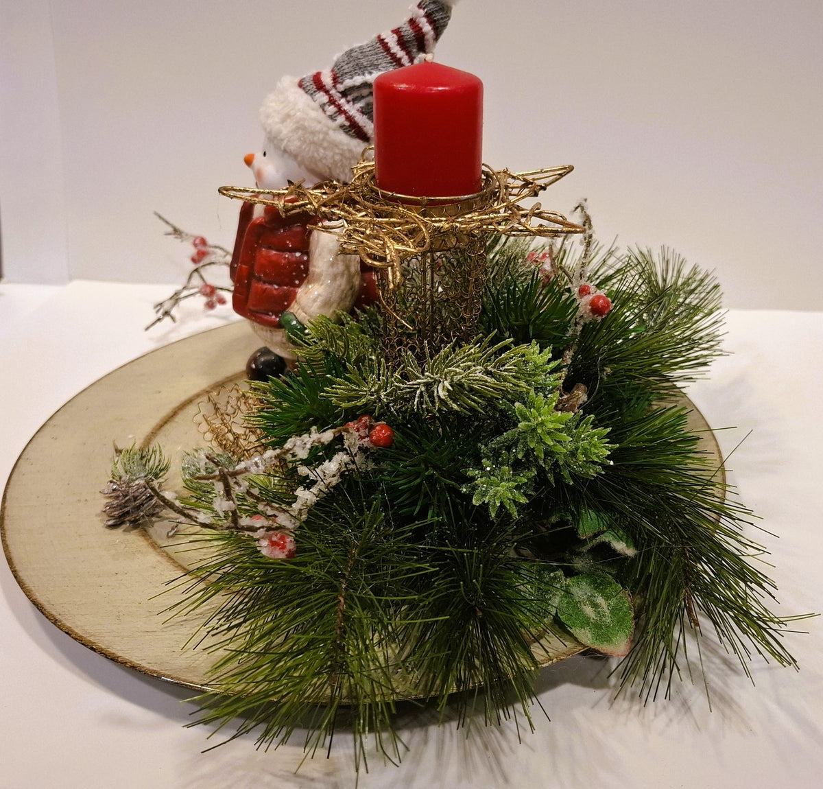 Weihnachtsgesteck mit roter Kerze im sternförmigen Halter