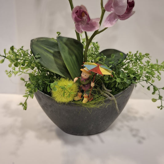 Detailansicht der kleinen Figur mit buntem Schirm und des grünen Beiwerks