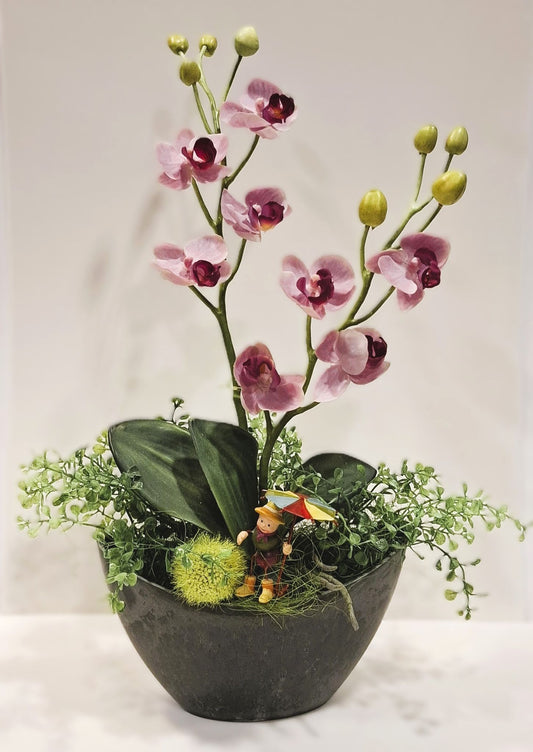 Orchideen-Gesteck mit rosa Blüten im dunklen Kunststoff-Schiffchen – Gesamtansicht