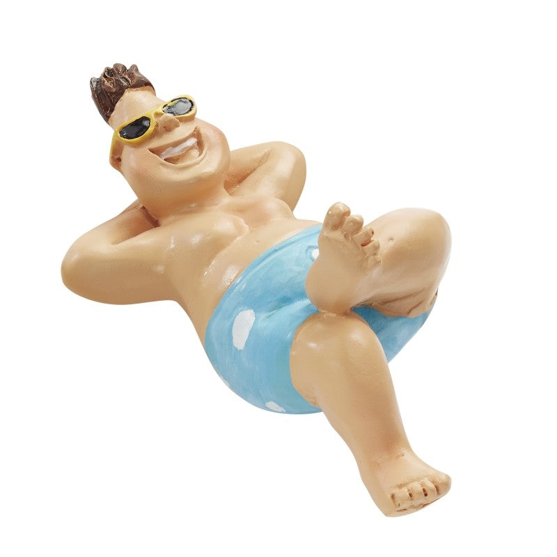 Zurückgelehnter Miniatur-Urlauber mit Sonnenbrille, Händen hinter dem Kopf und blauer Badehose mit weißen Punkten