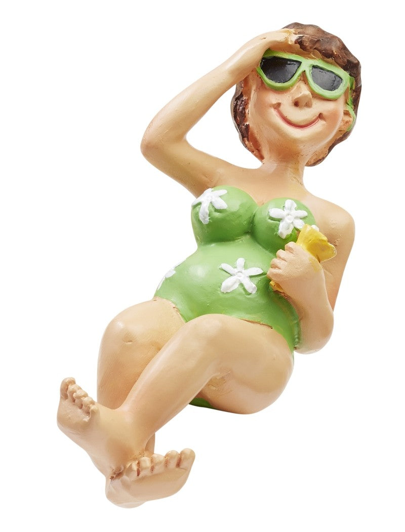 Zurückgelehnte Miniatur-Urlauberin mit grüner Sonnenbrille und grünem Badeanzug mit weißen Blumen