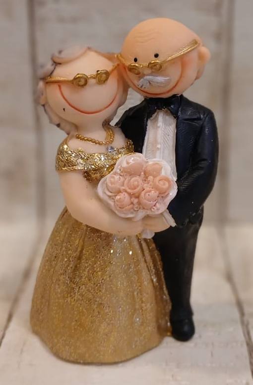 Brautpaar zur goldenen Hochzeit mit Brillen und rosa Rosenstrauß, Braut im goldfarbenen Kleid vor Bräutigam im schwarzen Anzug, BP-G003